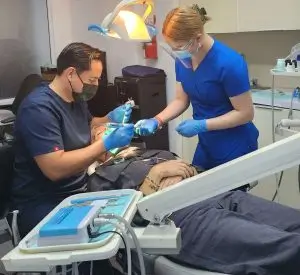 Dentist and dental assistant providing patient care at Dr. Mexico Dental Group in Tijuana, Mexico