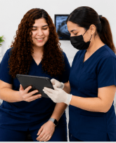 Dra. Evelyn Tirado reviewing patient information with a clinical team member at Dr. Mexico Dental Group