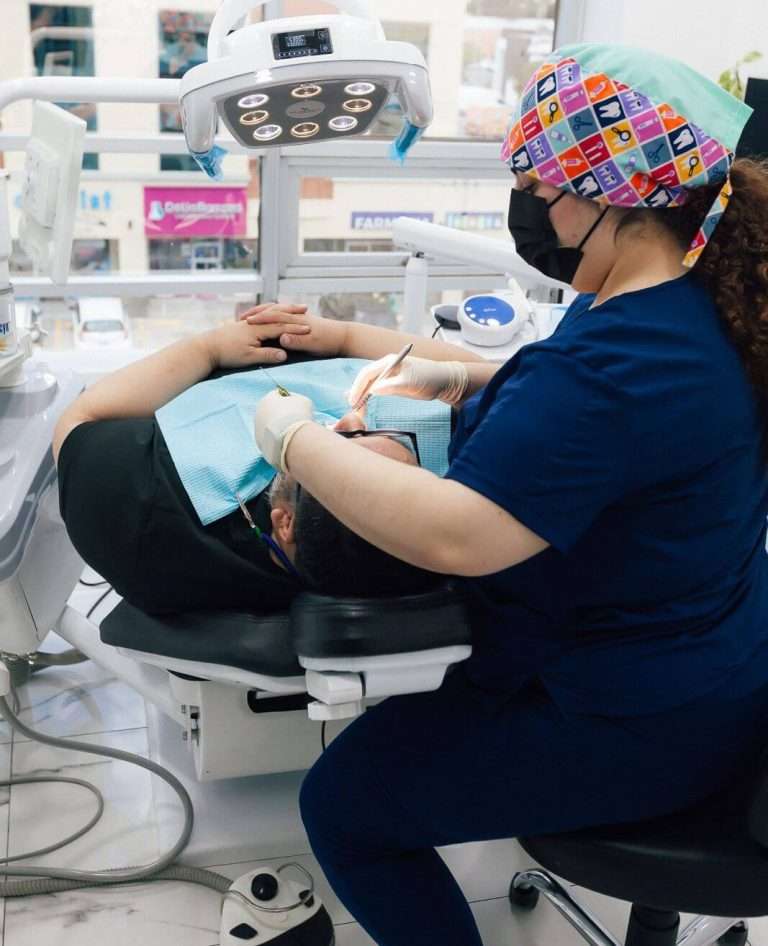 Dra. Evelyn Carolina Tirado Parra providing dental treatment to a patient in a modern dental clinic in Tijuana, Mexico.